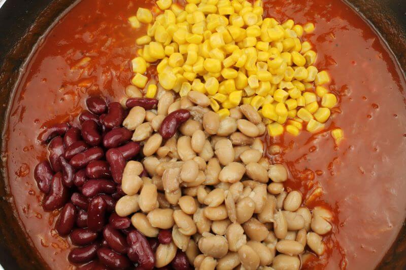 weiße Bohnen, Kidneybohnen und Maiskörner, alles aus der Dose, werden in die Tomatensosse eingerührt und erwärmt.